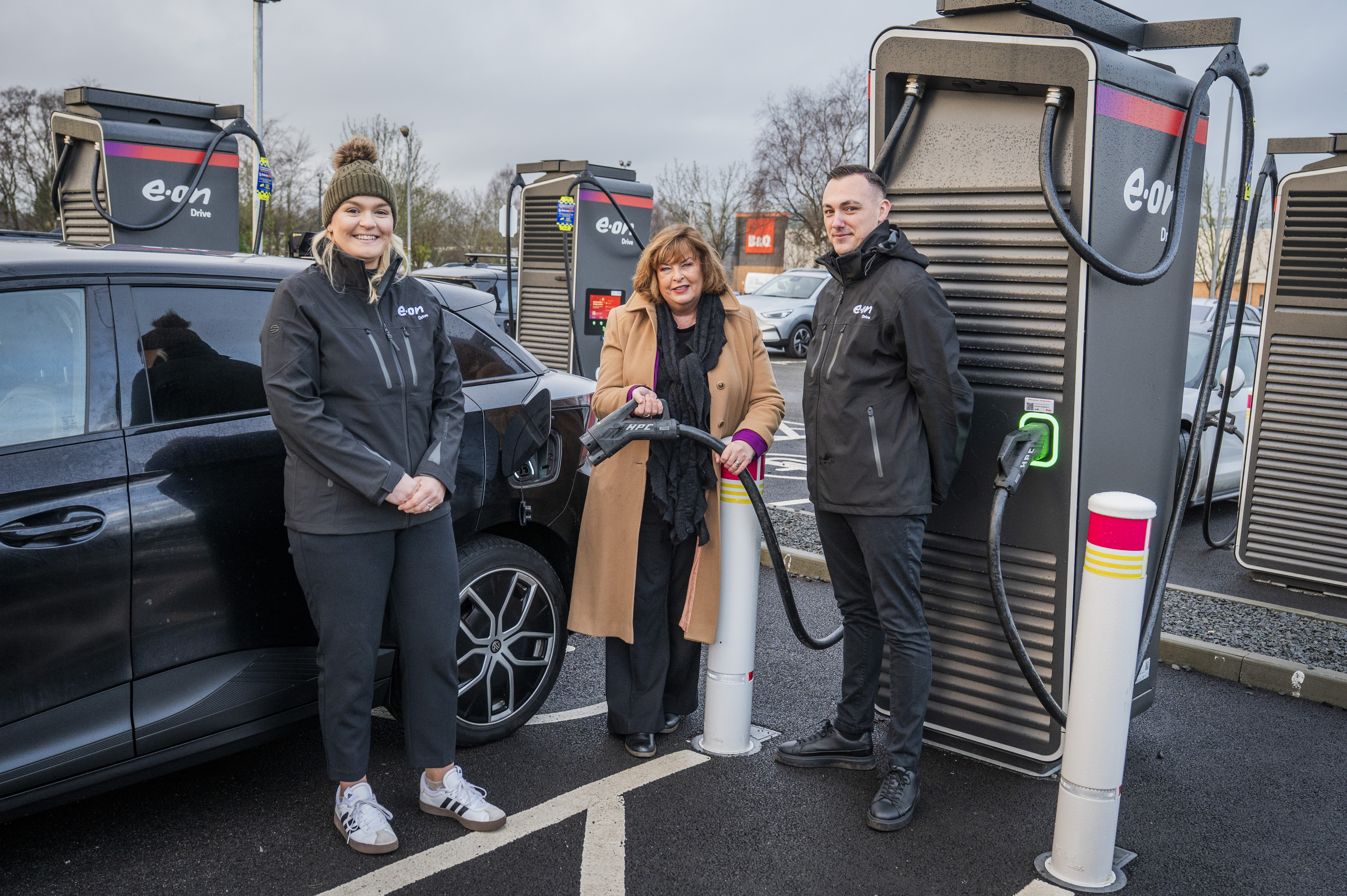 Transport Secretary Fiona Hyslop poses for a photo with E.ON staff at an EV charging station.