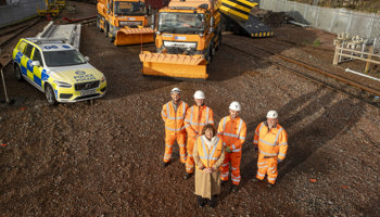 Transport Secretary Fiona Hyslop poses for a photo with winter service colleagues, in front of resilience vehicles at a rail depot.