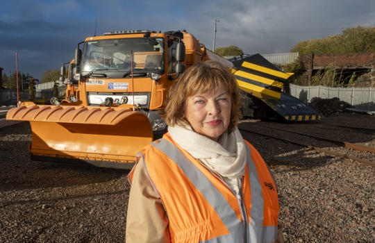 Transport Secretary Fiona Hyslop poses for a photo in front of a gritter and a snow plough train.