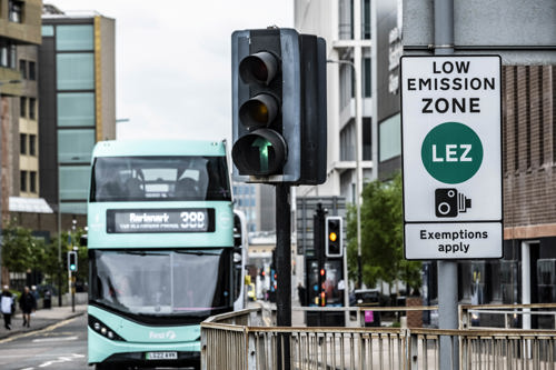 View of a street in Glasgow including a bus, traffic lights and Low Emission Zone sign