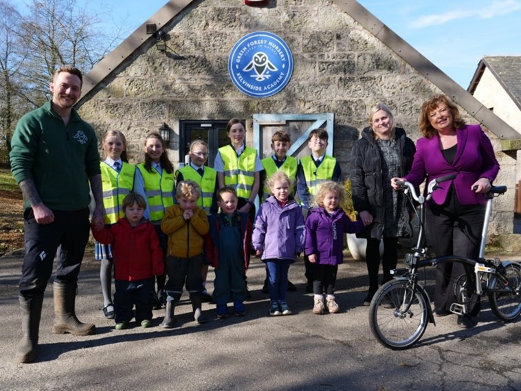 Cabinet Secretary for Transport Fiona Hyslop at Kelvinside Academy Green Forest Nursery with staff and pre-school children, alongside pupils from Milngavie Primary