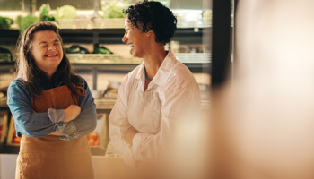 Two people laughing in a grocery store